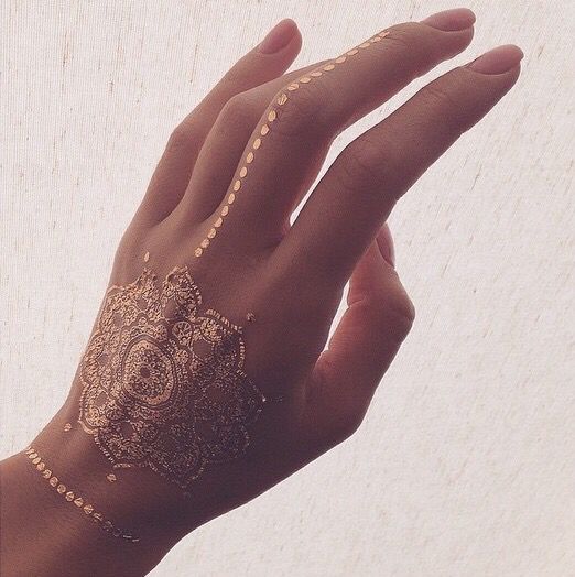 Picture Of gorgeous mandala gold henna tattoo on the hand, finger
