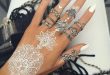 Picture Of lacey white henna tattoo on the hand and white manicure