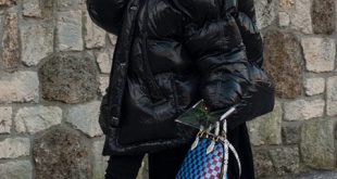 A street style image of a black oversized puffer jacket, boots
